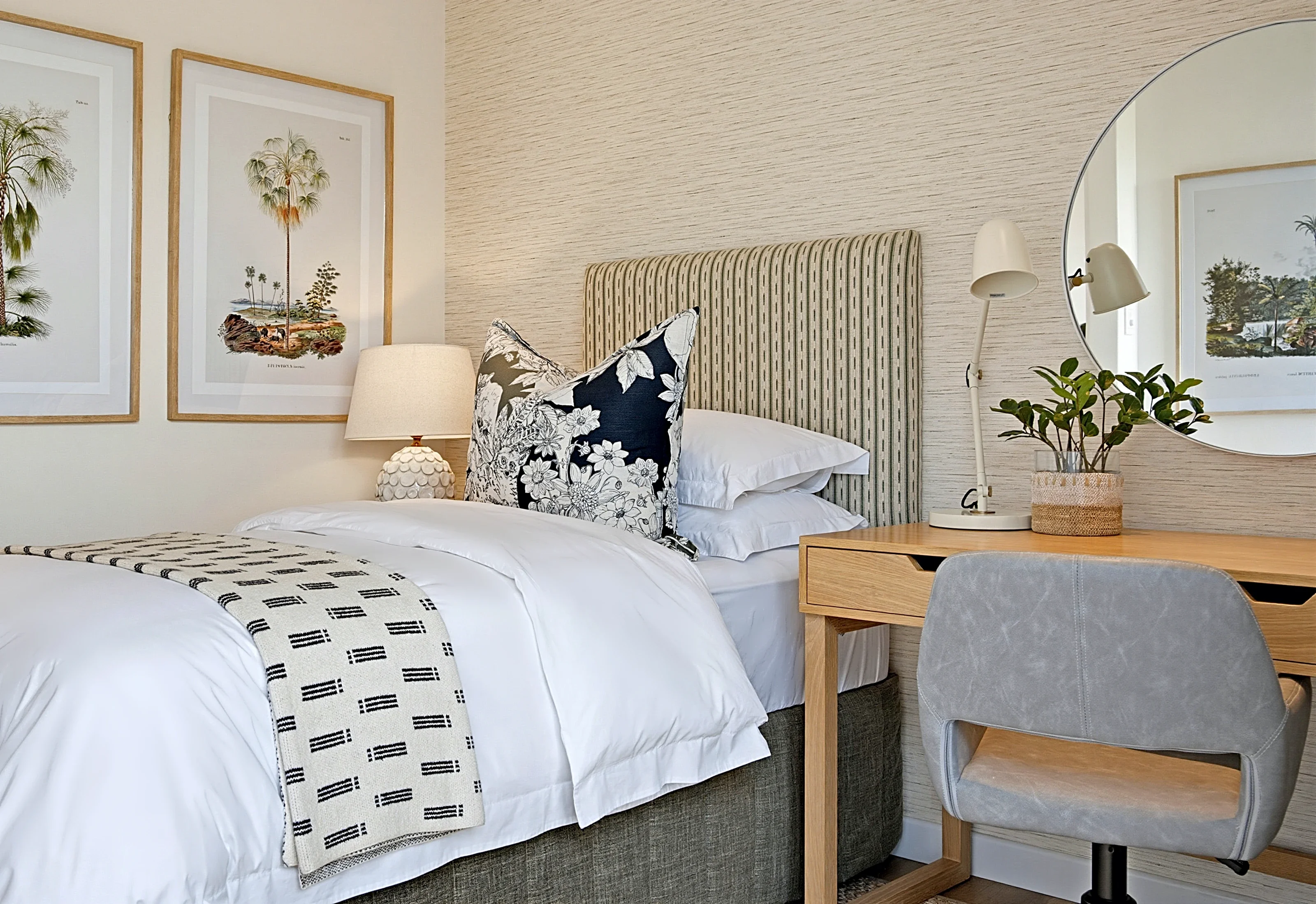 Second guest bedroom at Simbithi Eco-Estate: a sage and charcoal ticking-stripe headboard, a cane-fronted bedside, a desk and palm botanical prints