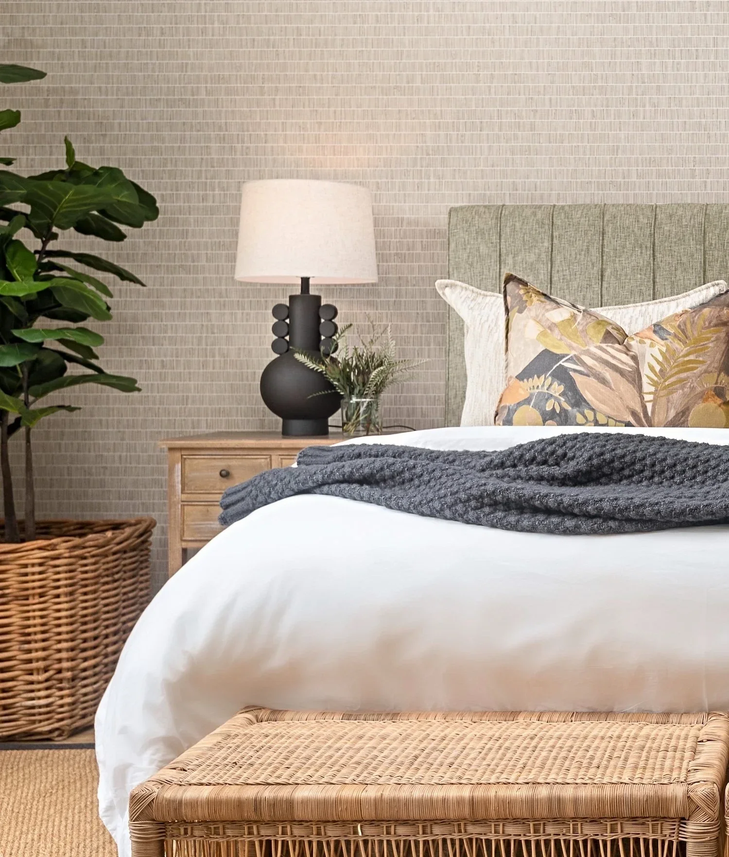 Bedroom at Loxley Estate, Sheffield Beach: a dark patterned cushion, natural linen bedding and a potted plant