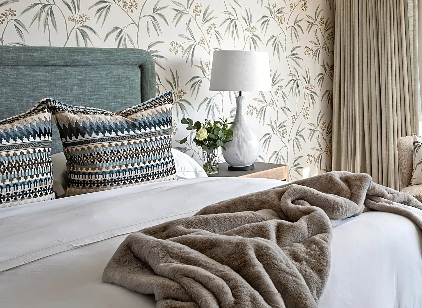 Main bedroom at The Glen, towards the window: two boucle swivel chairs, a green ottoman and the mountain