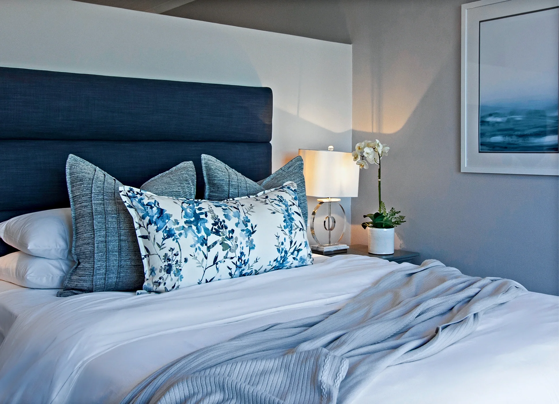 Main bedroom at Kenton-on-Sea: navy headboard, blue and white cushions, sea view