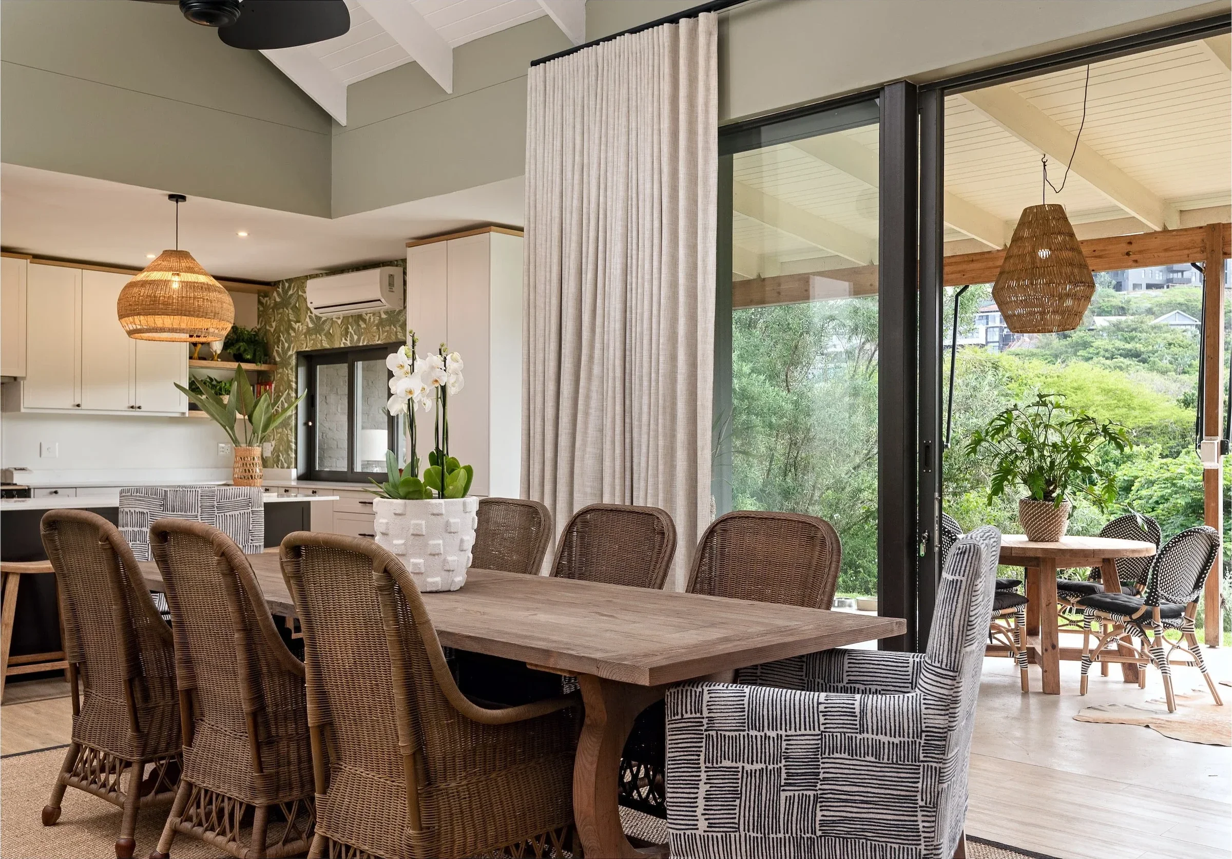 Dining room at Loxley Estate: a long timber table beside glass doors to the terrace