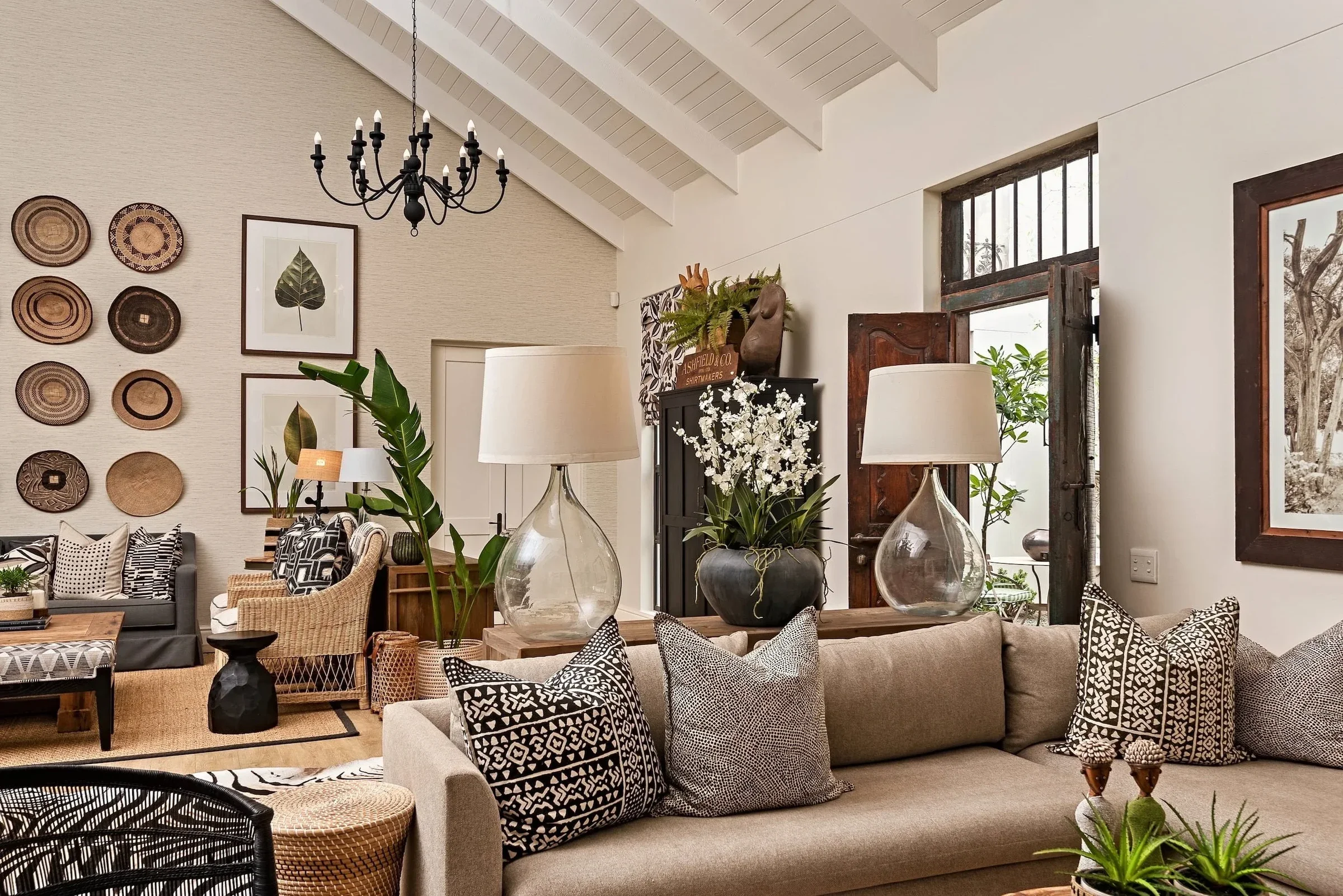 Living room at Loxley Estate under a pitched ceiling, with the basket wall and stone linen sofas