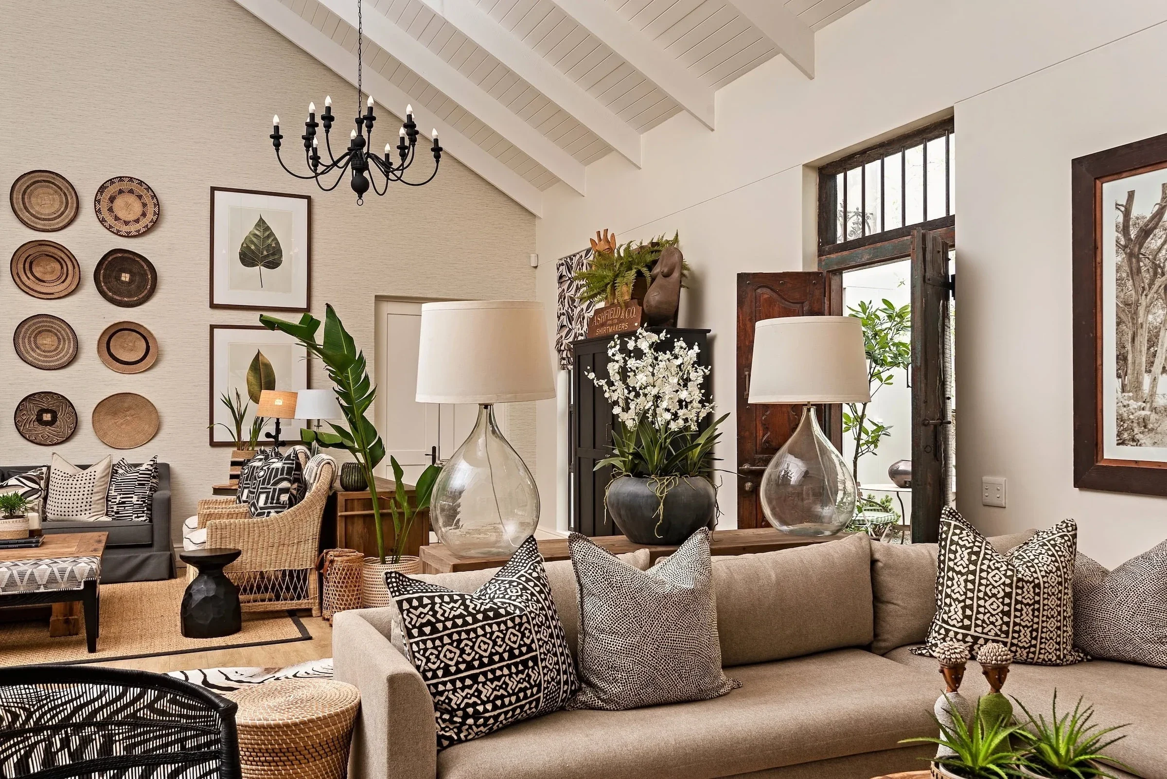 Living room at Loxley Estate: a wall of woven baskets, a beige sofa and patterned cushions