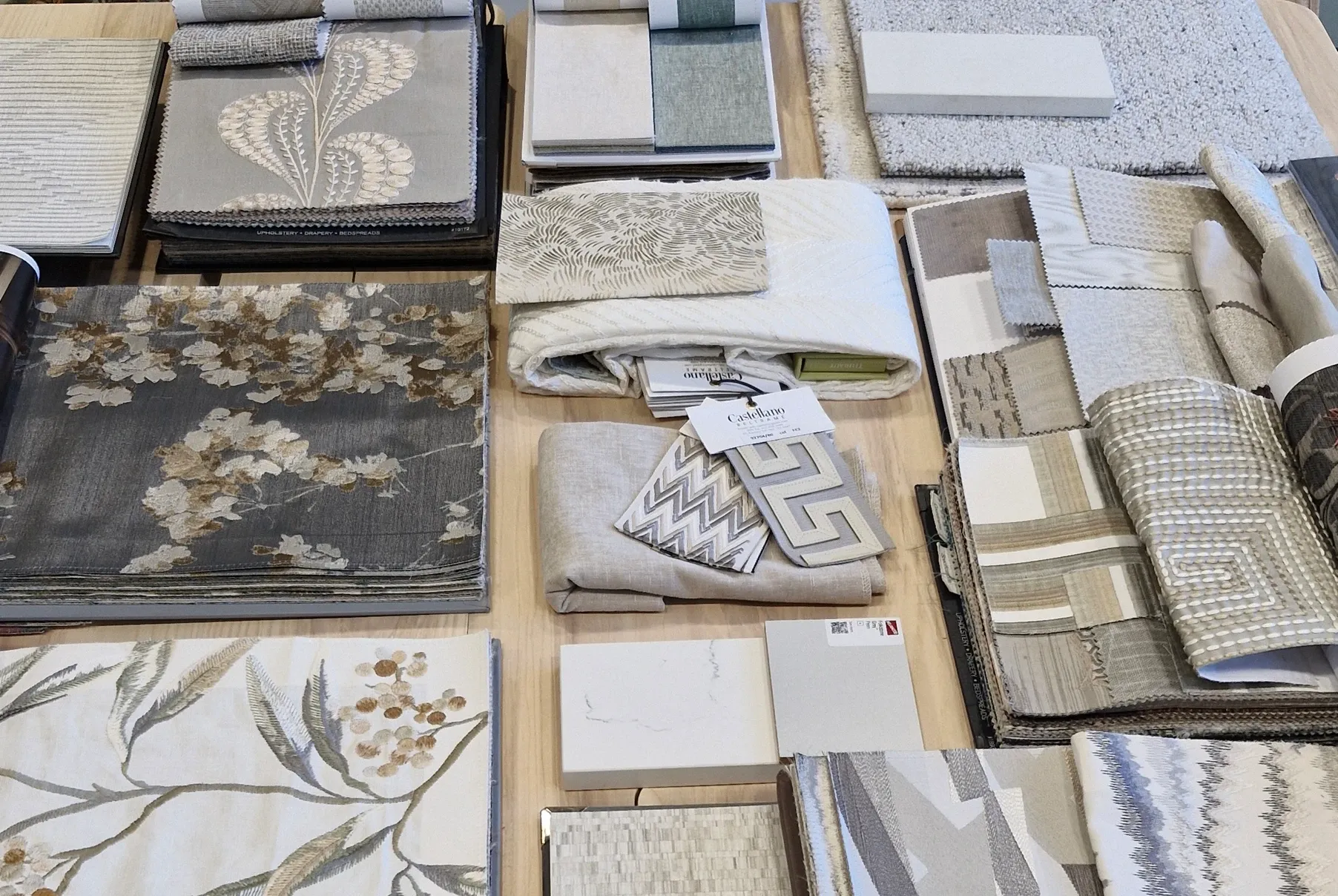 Fabric, wallpaper, carpet and stone samples laid out on a table for selection