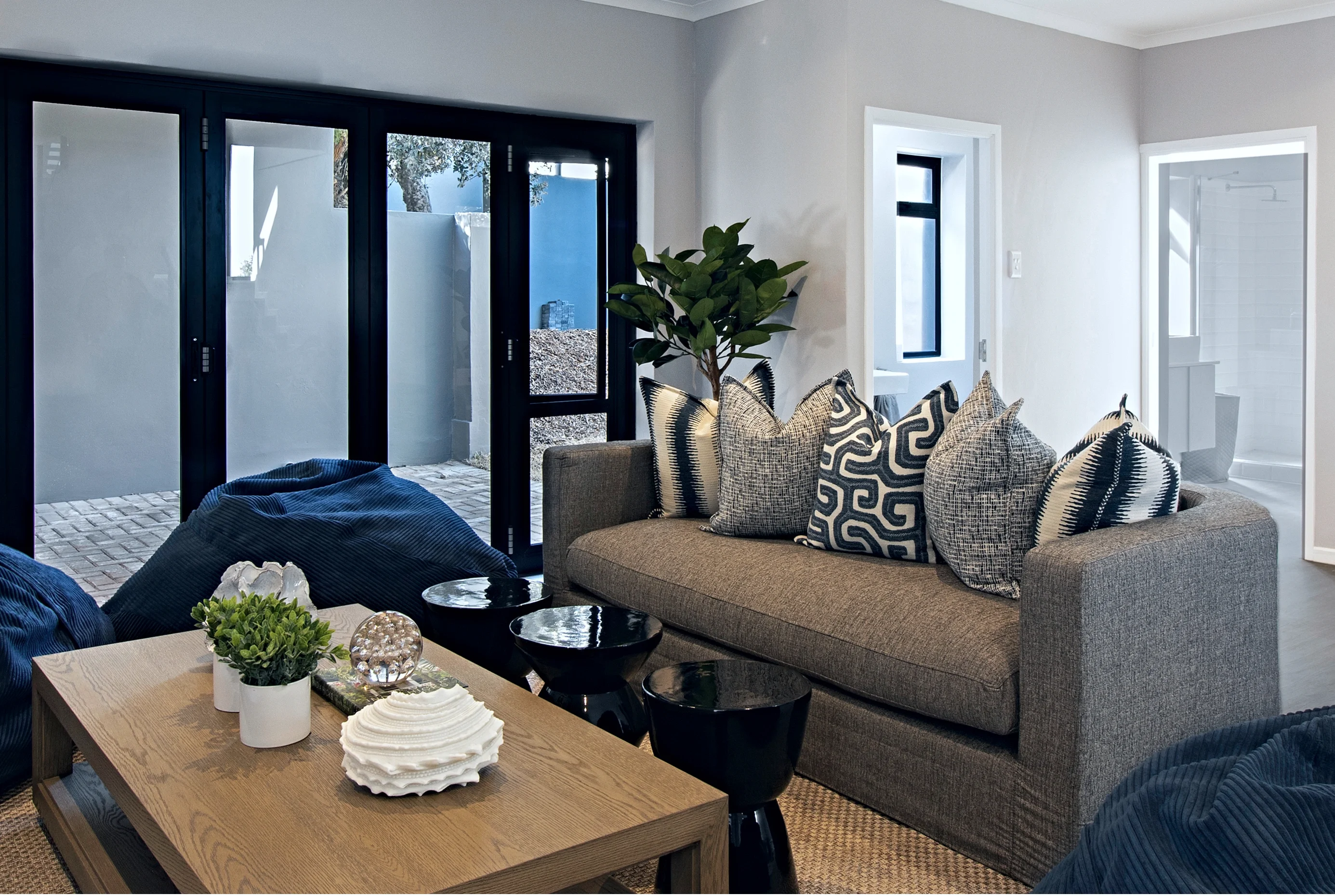 TV room at Kenton-on-Sea: grey sofa, navy beanbags and a rectangular timber table
